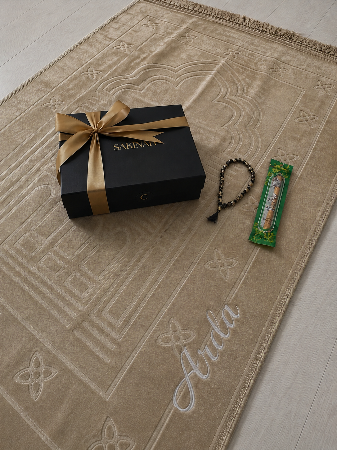 Gebetsteppich beige, Aufschrift Arda, darauf eine Geschenkbox, Tesbih und Miswak