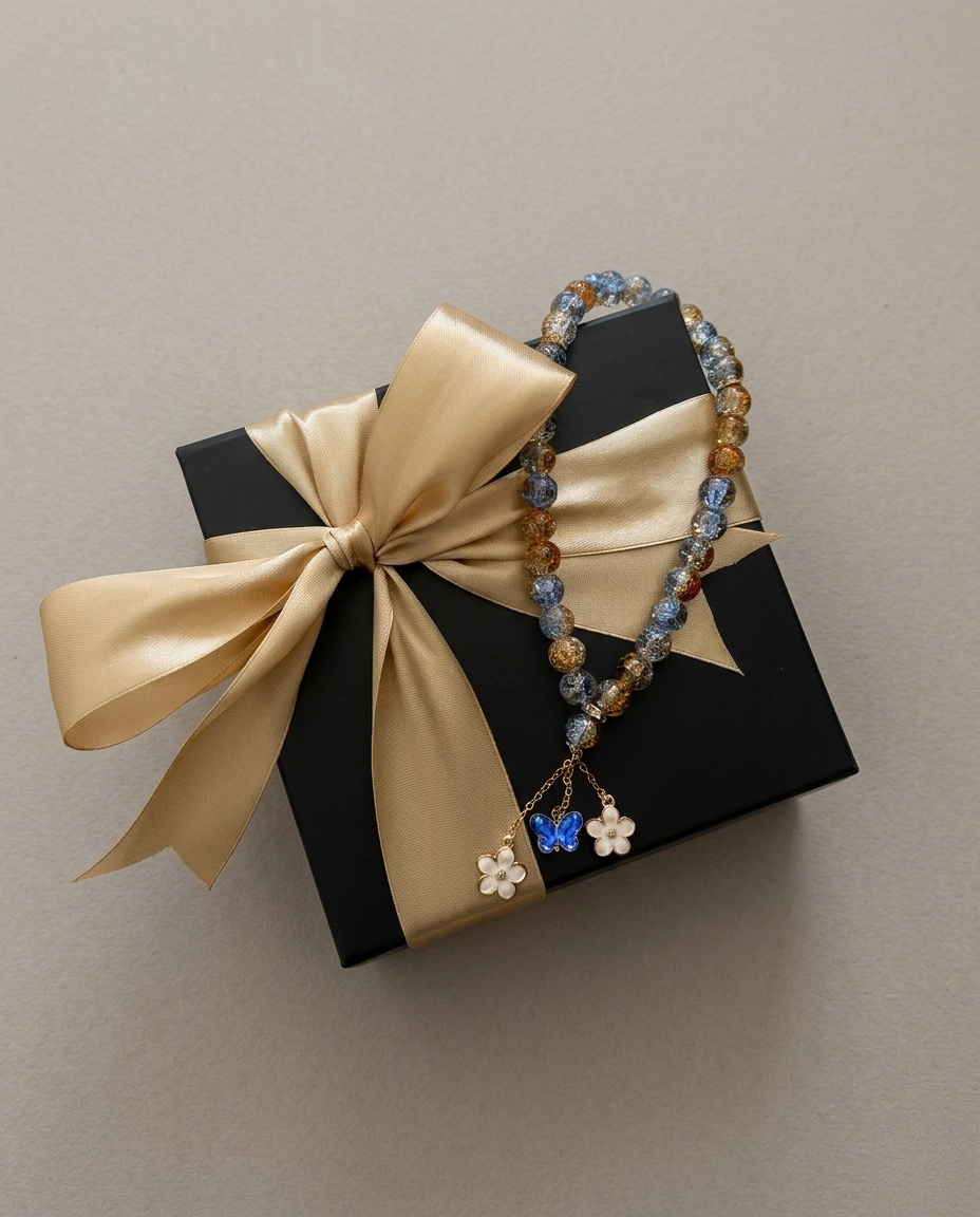 Gebetskette (Tesbih) auf einer schwarzen Geschenkbox mit goldenem Geschenkband